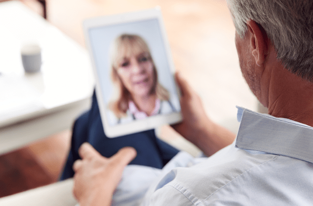 man video conferencing on tablet with doctor - telemedicine