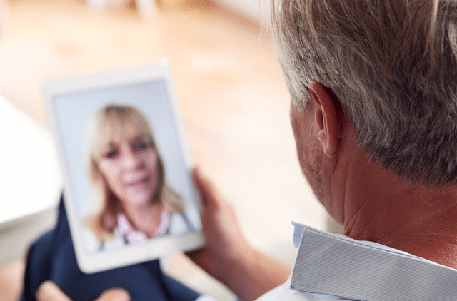 man speaking to doctor on tablet