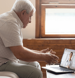 Older man having telehealth visit on laptop